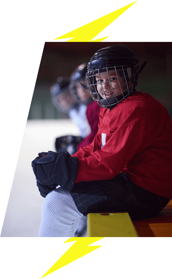 Kids hockey player sitting on the bench smiling VI Storm Athletics