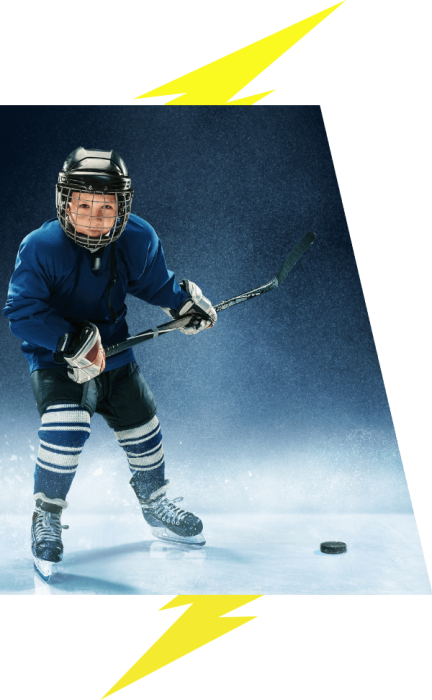 A young boy hockey player poses for a photo with a puck.
