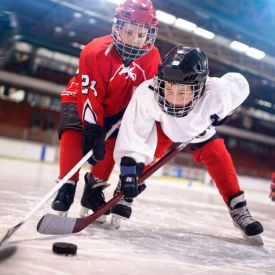Group of kids hockey players fighting after the puck 